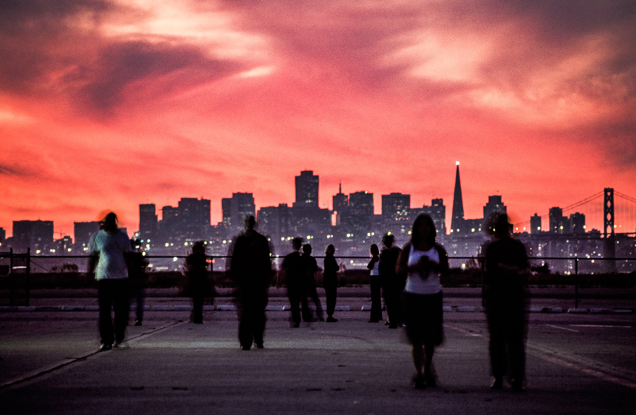 People watching a city skyline at sunset